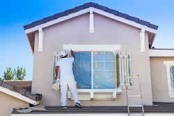 Photo of a two-story house being painted on the outside.